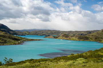 blue lake among mountains with a ship on it