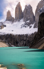 las torres covered by snow with blue lake at the front