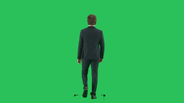 Back shot of male model in suit isolated on chroma key green screen background. Young businessman office worker in suit walking with back at camera.