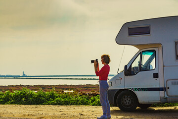 Woman on caravan trip take photos with camera, Spain
