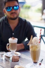 man sitting drinking coffee at a coffee shop