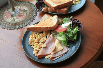 American Breakfast egg ,ham, sausages, bacon, tomato, toasts bread and salad on wooden table. Eating healthy in morning.