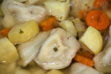 Pelmeni-Suppe/Eintopf mit Kartoffeln, Möhren und Zwiebeln.