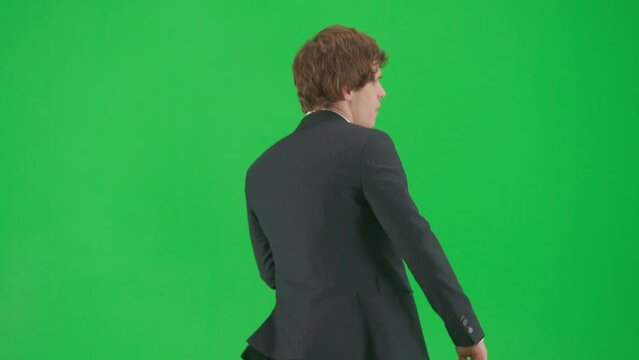 Portrait of male model in suit on chroma key green screen background. Stylish young businessman in trendy suit walking and dancing.