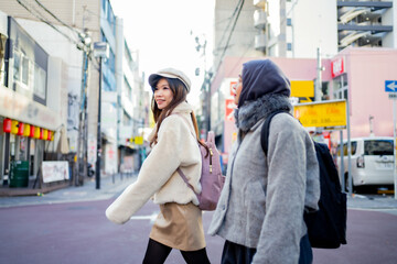 Obraz premium woman girl tourist Two Asian friends but different religions, one of whom is a Muslim girl. Walking tour of the city, city view, traveling in Japan. with fun She is traveling in the city area.