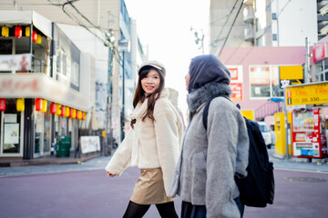 woman girl tourist Two Asian friends but different religions, one of whom is a Muslim girl. Walking tour of the city, city view, traveling in Japan. with fun She is traveling in the city area.