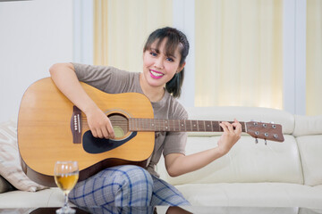 Picture of pretty girl learning to play an acoustic guitar