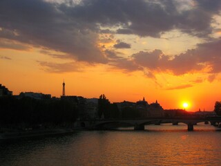 Sunset, Eiffel tower and Paris cityscape silhouette reflecting on water of Seine river in Paris,...