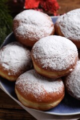 Delicious sweet buns with powdered sugar on table, closeup