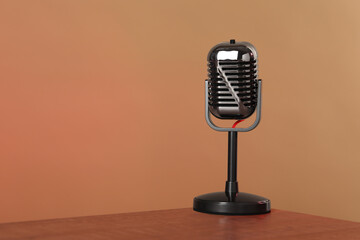 Vintage microphone on table against color background, space for text. Sound recording and...