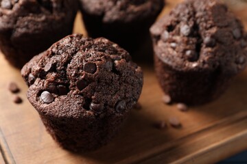Delicious chocolate muffins on wooden board, closeup - obrazy, fototapety, plakaty
