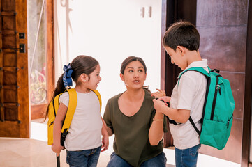 Latin mother talks to her children before they leave for school, gives them instructions on good behavior.