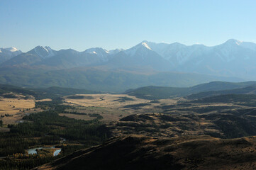 View from the top of the hill to the winding bed of a beautiful river flowing through a coniferous...
