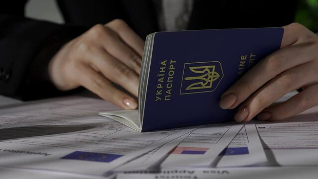 Close up shot of usa and europe union visa application documents. Female worker holding ukrainian passport, puts stamp with approve mark on it.