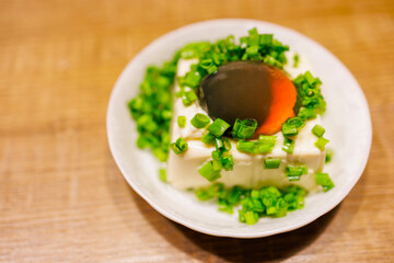 a plate of exquisite century egg tofu, sprinkled with fresh green onions