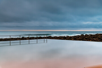 Obraz premium Rainy day sunrise at the beach and ocean pool
