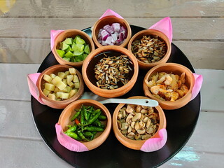 Miang kham : Savoury Sacred pink Lotus leaf Wraps or Piper sarmentosum leaf Wraps is traditional snack appetizer from Thailand. Arrange ingredients into clay cups such as dried shrimp, ginger, onions,