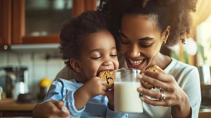 Rolgordijnen Happy African American family: Mother and little son eat cookies with milk for breakfast at home © Sasint