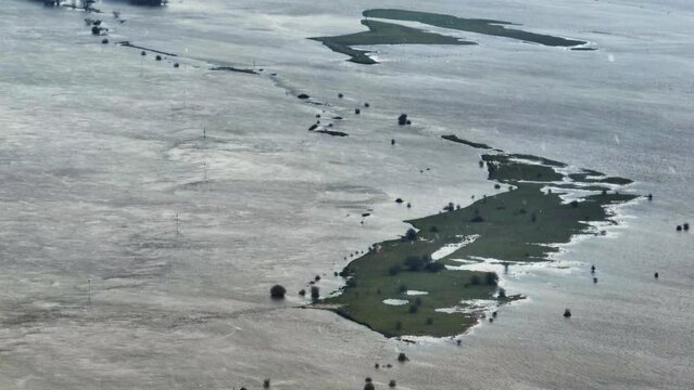 Aerial orbiting views of flooded farm fields near Gorinchem Netherlands, in early January of 2024 with a light snow fall in the foreground