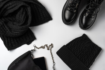 Winter total black accessories on white background. Flat lay, top view.