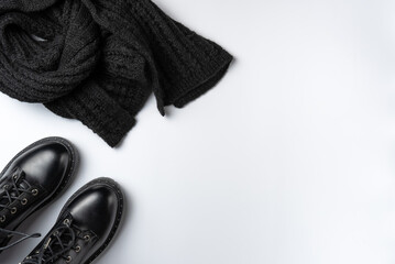 Black boots and scarf on a white background. Copy space
