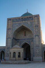 Fototapeta na wymiar View to Mir i Arab madrassa through old wooden carved door, Bukhara, Uzbekistan