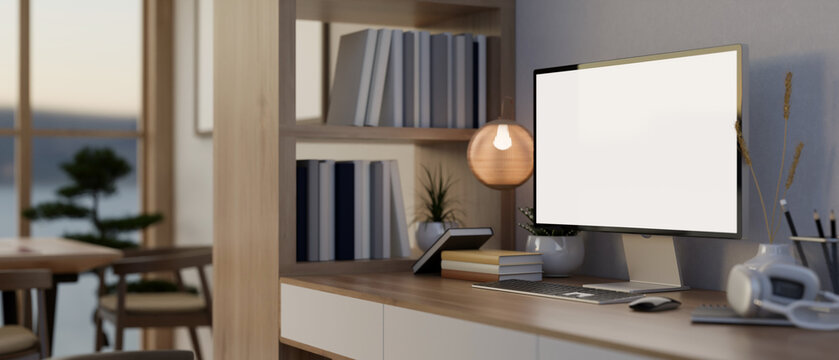 A PC computer and accessories on a table, a wooden bookshelf, and decor in a modern office room.