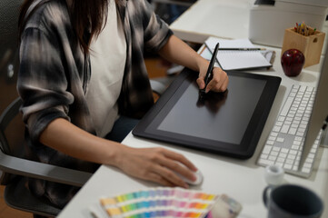 Close-up image of a professional female graphic designer illustrator artist working in the office.