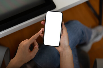 Top view image of a woman using her smartphone in the office. A white-screen smartphone mockup.