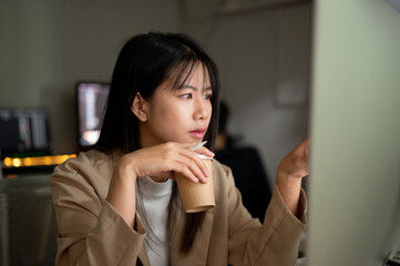 A dissatisfied businesswoman is reading emails, looking at her computer screen with a serious face.