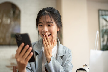 A woman is looking at her phone screen with a surprising face, surprised with an online promotion.