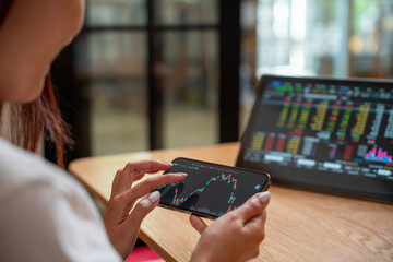 Successful smart woman investor and crypto trader, using laptop and smartphone,