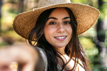 Portrait of a woman with a straw hat in the forest