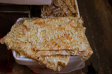 Stacks of thin, transparent dried fish sheets in Samaki Market showing the authentic khmer food,...