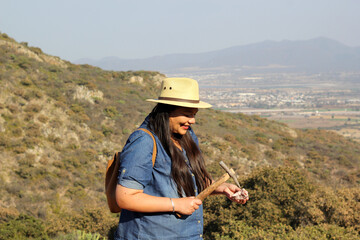 Latin adult woman geologist studies the details and characteristics of rocks, minerals and fossils...