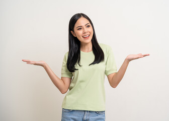 Beautiful smiling happy young asian woman in green shirt. Charming female lady open hands palm up holding something on isolated white background. Asian woman cute Pretty people looking blank space.