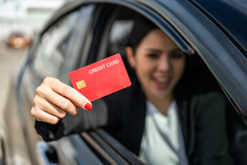 Young beautiful asian business women getting new car. Hand holding credit card payment. Car owner paying fuel pump with credit card customer mileage point loyalty reward. Driving vehicle on the road - obrazy, fototapety, plakaty