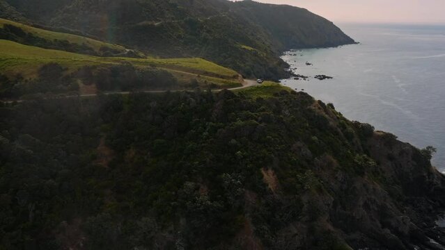 Aerial: Coastal farmland and ocean in Fletcher Bay, Coromandel Peninsula, New Zealand.