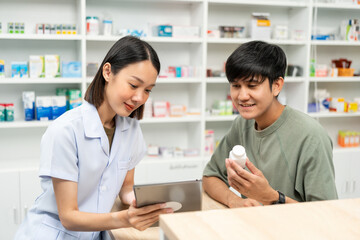 Obraz premium Pharmacist recommends medicines to customers.Taking the questions of medication. Asian female pharmacist giving prescription medications to customers at drugstore shelves.