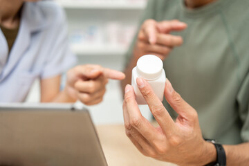Pharmacist recommends medicines to customers.Taking the questions of medication. Asian female...