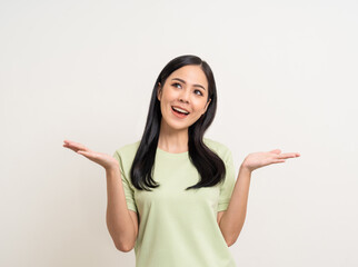 Beautiful smiling happy young asian woman in green shirt. Charming female lady open hands palm up...