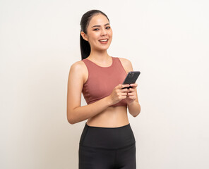 Naklejka premium Young beautiful asian woman with sportswear using smartphone on isolated white background. Attractive Portrait latin sporty woman standing pose holding cell phone exercise workout in studio.