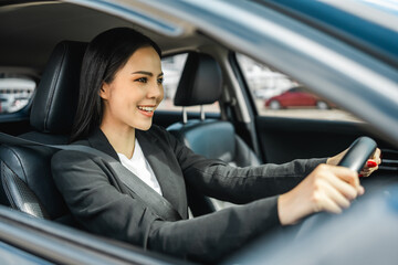 Young beautiful asian business women getting new car. She very happy and excited. Smiling female...