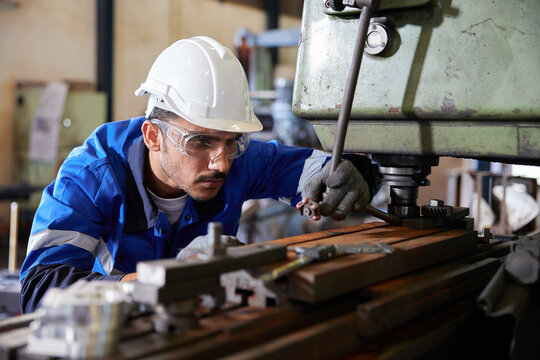 factory worker or technician checking and control lathe machine in factory