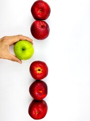 Hand pulling green apple from red Apple white background clipping path
