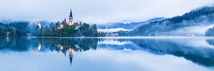 Deurstickers Lake Bled Slovenia with the small island in the middle of the lake and the old church at sunrise with mist over the lake. © Bruce Aspley