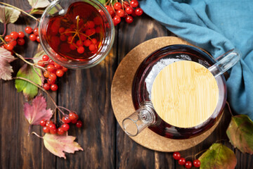 Autumn tea, berry vitamin seasonal drink. Viburnum and cup of healthy viburnum tea on a wood background. View from above. - obrazy, fototapety, plakaty