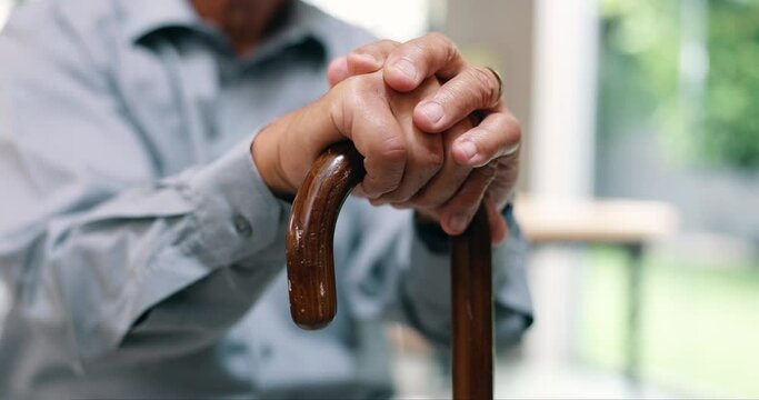 Hands, senior man and walking stick in closeup for recovery, balance and rehabilitation in nursing home. Retirement, wood cane and mobility aid for steps, movement and person with disability in house