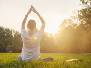 Young asian woman doing meditation in morning or evening at park, healthy woman relaxing and practicing yoga at city park. Mindfulness, destress, Healthy habits and balance concept