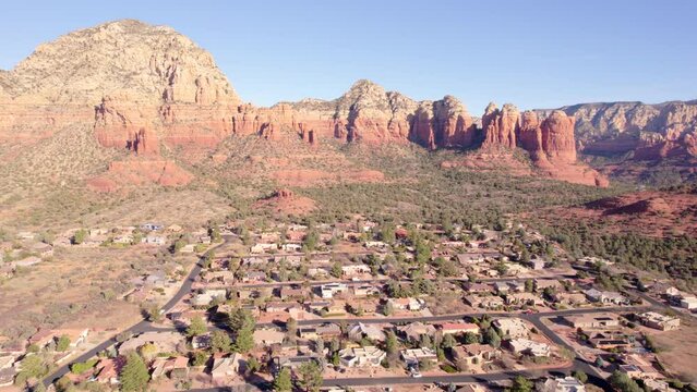 Aerial View of Sedona, Arizona, Residential Neighborhood, Houses and Streets Under Red Rock Cliffs and Formations, Drone Shot